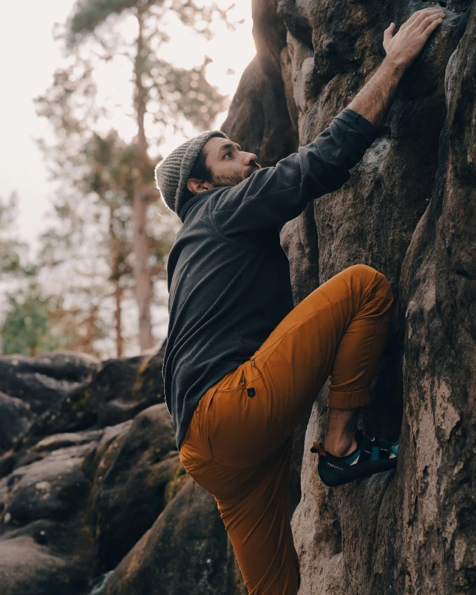 a man climbing up the side of a mountain